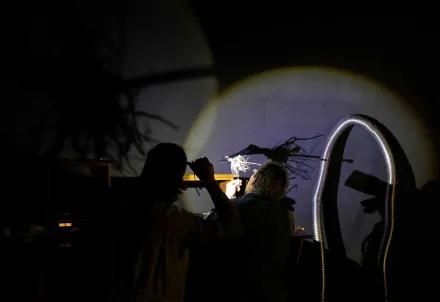 Zwei Personen erzeugen mit Licht und Objekten poetische Schattenspiele.