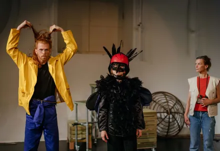 Szenenbild mit drei Performer*innen – humorvoll, farbenreich und voller Ausdruck.