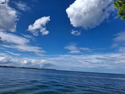 Gewässer, leicht gekräuselte Oberfläche (schwacher Wind), blauer Himmel mit Wolken