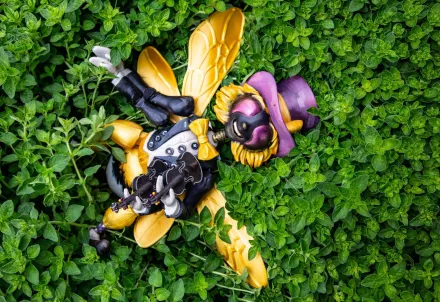 Eine Insektenfigur mit Hut und Geige liegt entspannt im grünen Blattwerk.